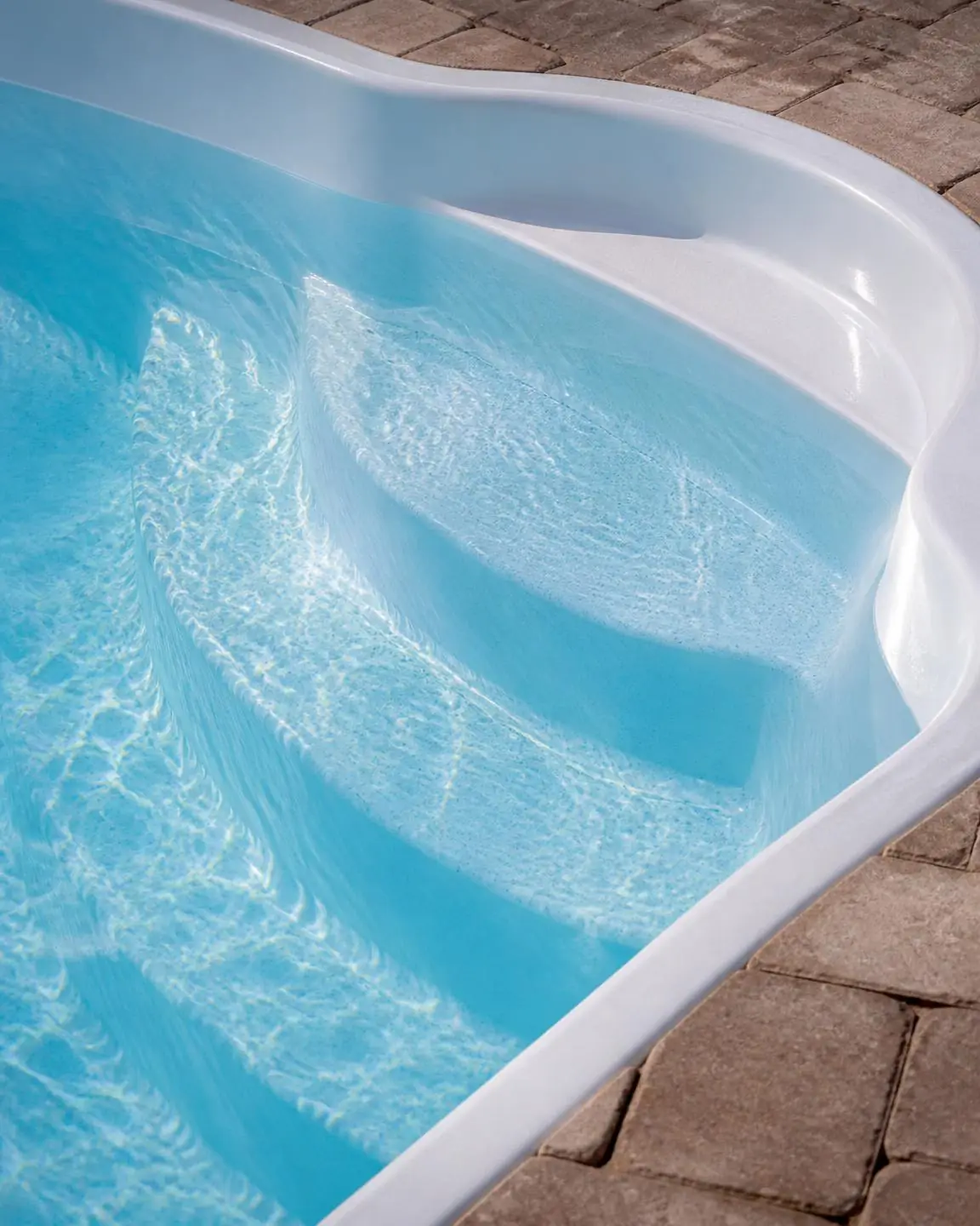 Fiberglass pool step entry with clear blue water
